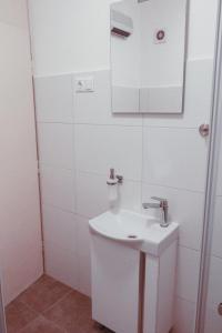 a white bathroom with a sink and a mirror at Apartment Dream of Split in Split