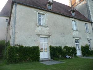 ein altes Haus mit einer weißen Tür und Fenstern in der Unterkunft Le Claveau in Paulnay
