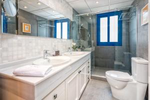 ein Badezimmer mit zwei Waschbecken und einer Toilette und einem Spiegel in der Unterkunft iloftmalaga Ático Pacífico 19 A in Málaga