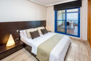 ein Schlafzimmer mit einem Bett und einem Tisch mit Aussicht in der Unterkunft iloftmalaga Ático Pacífico 19 A in Málaga