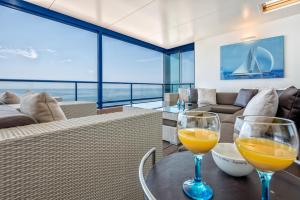 2 Gläser Orangensaft auf einem Tisch im Wohnzimmer in der Unterkunft iloftmalaga Ático Pacífico 19 A in Málaga