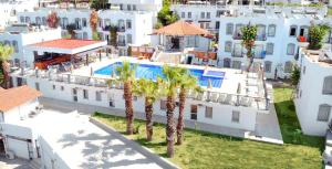 an aerial view of a building with a pool and palm trees at Maison 48 Apart Hotel in Gümbet