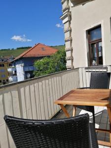 a wooden table and chairs on a balcony at Charming City Apartment with parking spot in Würzburg