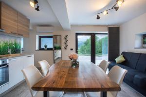 a kitchen and dining room with a wooden table and chairs at Chilly apartment in Bled
