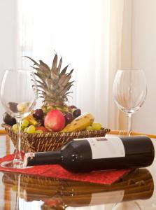 a table with two wine glasses and a basket of fruit at Kekova Hotel in Kaş