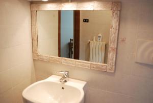 ein Bad mit einem Waschbecken und einem Spiegel in der Unterkunft Casa rosa sull'appennino tosco emiliano in Barigazzo