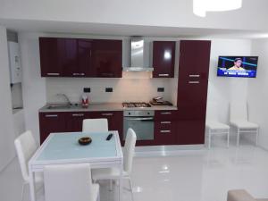 eine Küche mit einem Tisch und eine Küche mit einem TV in der Unterkunft Zona chiesa russa in Sanremo