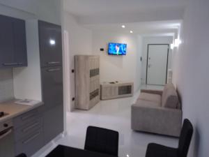 ein Wohnzimmer mit einem Sofa und einem TV an der Wand in der Unterkunft Zona chiesa russa in Sanremo