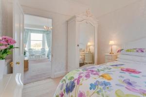 a bedroom with a bed with a floral bedspread at Barnes Fell Apartments in Ambleside