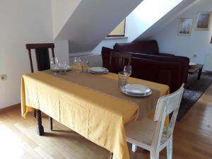 a dining room table with a yellow table cloth on it at Apartma Dolomiti in Ljubljana