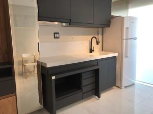 a kitchen with a sink and a refrigerator at Studio Lux West Flat in Mossoró