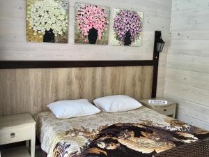 マツェスタにあるGuesthouse Staraya Matsestaのベッドルーム1室(壁に絵画2点が飾られたベッド1台付)
