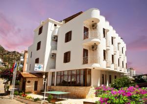 a white building with a table in front of it at Kekova Hotel in Kaş