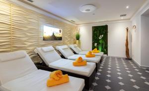 マイヤーホーフェンにあるApparthotel Königの白いソファ4脚と黄色いタオルが置かれた部屋