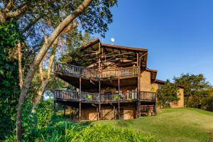 a house with a wrap around deck on a lawn at Ulwazi Rock Lodge in Hazyview