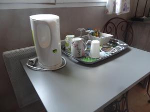 a table with a tray with a hair dryer and cups at Au Retour du Lac in Ardres