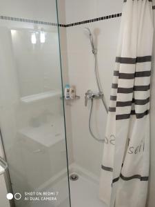 une salle de bain avec une douche avec une porte vitrée dans l'établissement Studio Sausset les pins, à Sausset-les-Pins