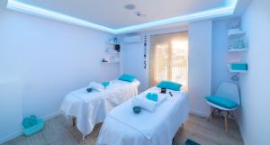 a blue room with two beds and a chair at Naiades Marina Hotel in Agios Nikolaos