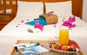 a tray of fruit and juice on a bed at Kekova Hotel in Kaş