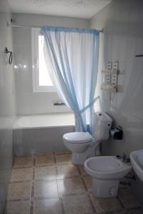 baño con aseo, bañera y ventana en Apartamentos Las Americas - Blanes Beach, en Blanes
