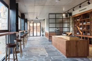 a tasting room with a bar and stools at Gillham Vineyard Hotel in Temblos