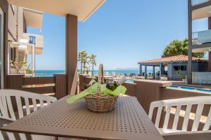 a table with a basket on a balcony with a view of the ocean at Girogiali beach hotel in Stalos