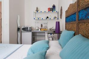 una camera da letto con letto con cuscini blu e una cucina di Centro Città Teatro a Trieste