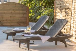 dwa wiklinowe krzesła siedzące na patio ze szkłem w obiekcie Vacation home Villa Santa Eufemia w mieście Sutomišćica