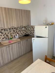a kitchen with a white refrigerator and a sink at Acropolis view apartment in Limenas