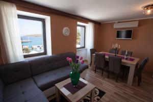 a living room with a couch and a table with a vase of flowers at Apartman M&S in Njivice