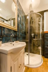 a bathroom with a sink and a shower at Apartament EmeryK in Krakow