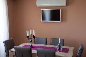 a dining room with a table with candles and a television at Apartman M&S in Njivice