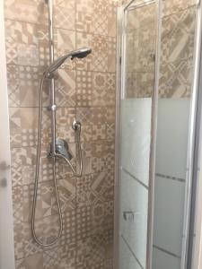 um chuveiro com uma porta de vidro na casa de banho em aQuamarina rooms em Termoli