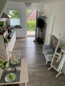 a living room with a table and a kitchen at Ferienwohnungen Seestraße in Börgerende-Rethwisch