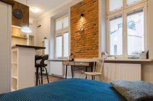 a bedroom with a bed and a desk and a brick wall at Apartament EmeryK in Krakow