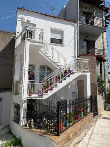a white building with stairs and flowers on it at Acropolis view apartment in Limenas