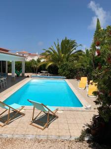 a swimming pool with two lounge chairs next to it at Holiday villa with pool near the ocean in Aljezur