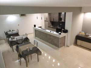 a kitchen and dining room with two tables and a counter at Vianova Affittacamere in Giurdignano