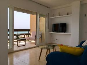 Una sala de estar con un sofá y vista al mar. en Beach front line luxury apartment, 2 bedroom, en El Campello
