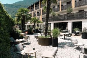 un patio avec des tables et des chaises en face d'un bâtiment dans l'établissement Hotel Traminerhof, à Termeno