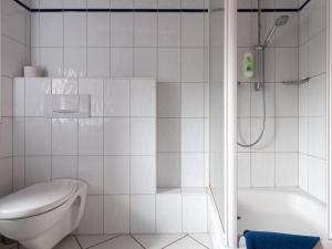 a white bathroom with a toilet and a shower at Gästezimmer im Weingut Wolf in Großkarlbach