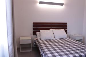 a small bedroom with a bed with a checkered blanket at Agriturismo Bacchanalis in Ziano Piacentino