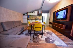 a living room with a couch and a table with yellow chairs at Hirande Uzungöl in Uzungol
