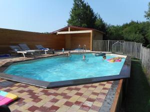 un gruppo di persone che nuotano in una piscina di Moulin de la Diversiere a Savigné-sous-le-Lude