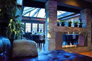 a living room with a fireplace and a table with chairs at Waterfalls Boutique Hotel in Pretoria