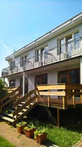 Pokoje Gościnne Bartek في ياستراوبيا جورا: مبنى امامه سطح خشبي