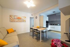 un soggiorno e una cucina con tavolo e sedie di Residence Due Perle a Lignano Sabbiadoro