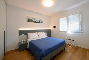 una camera con un letto blu e una finestra di Residence Due Perle a Lignano Sabbiadoro