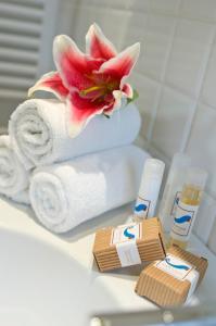 Hotel LaMorosa في ريميني: كومة من المناشف وردة على منضدة الحمام