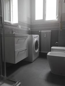 a bathroom with a washing machine next to a toilet at Assago Forum 12 in Assago